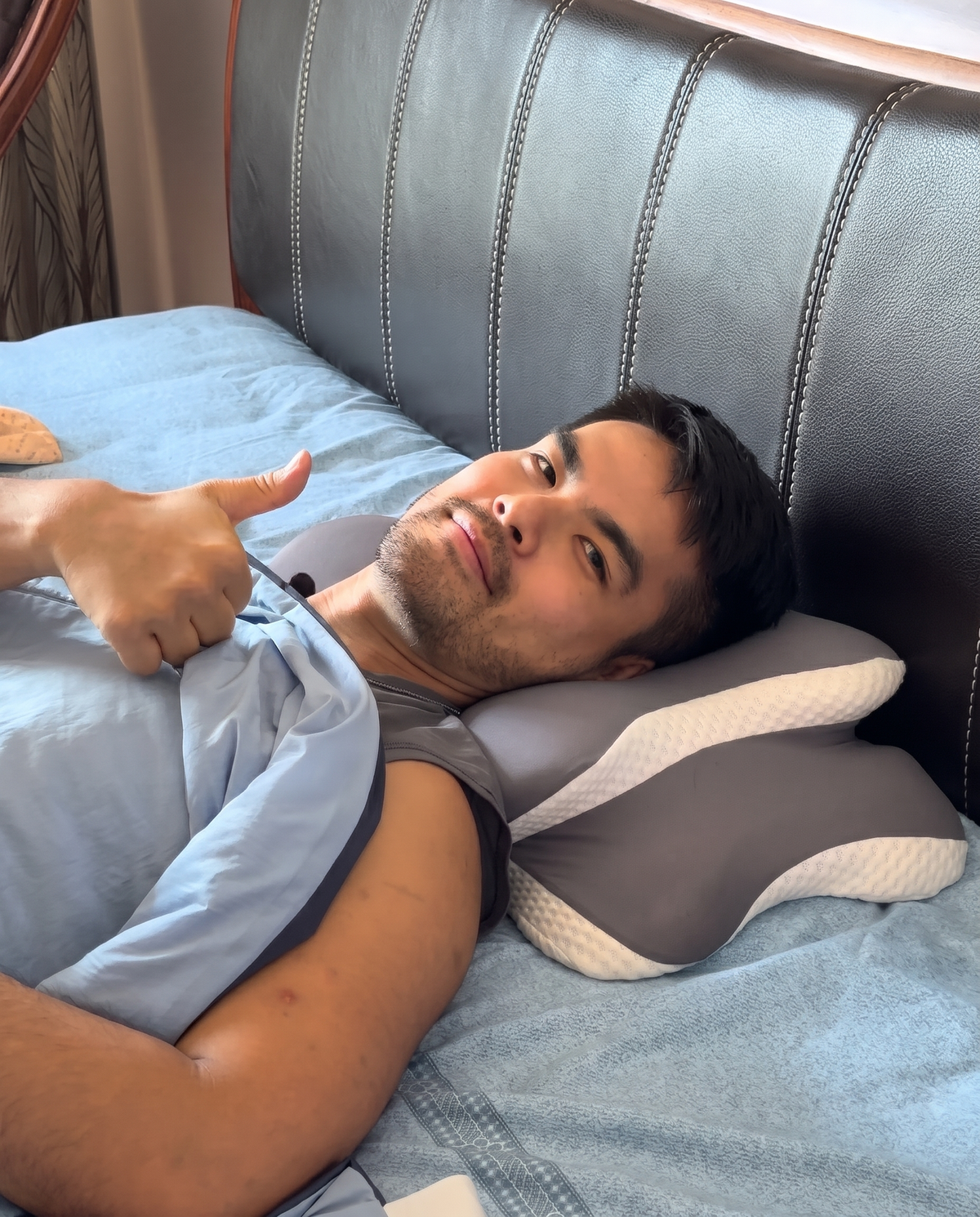 David, founder of Sleep Oasis, lying on the DreamButterfly cervical pillow and giving a thumbs up