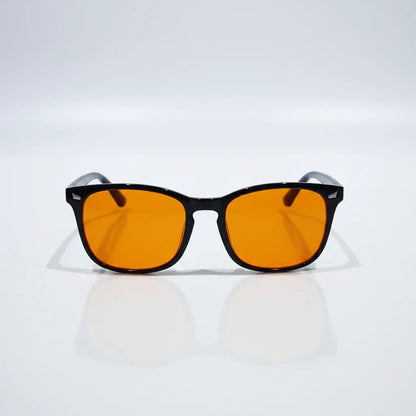 Orange-tinted blue light glasses with black frames for better sleep and eye relief