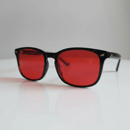 Red-tinted blue light glasses with black frames for better sleep and eye relief