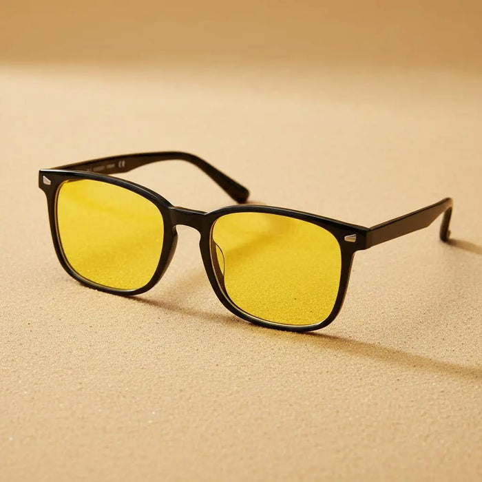 DreamShield blue light glasses with yellow lenses and black frames on a beige background
